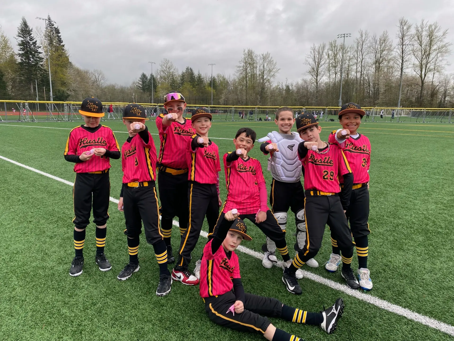 Players showing off their championship rings on a cloudy day, representing their dedication and teamwork.